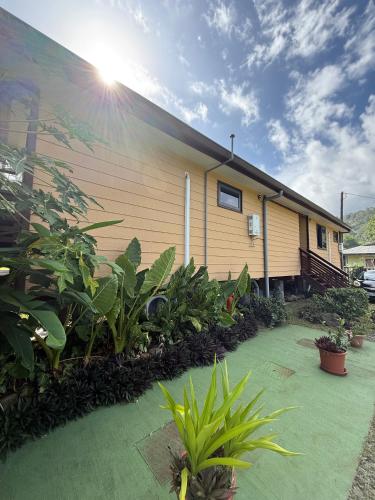 a building with a lot of plants in front of it at Hava'i Lodge in Taputapuapea