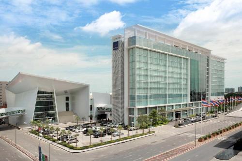 a large building with cars parked in front of it at Novotel Bangkok IMPACT in Nonthaburi