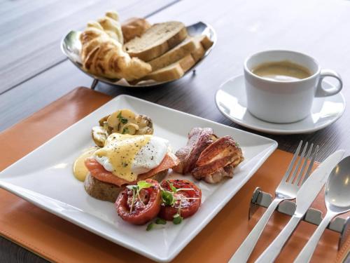 a plate of breakfast food with a cup of coffee and bread at Novotel Bangkok IMPACT in Nonthaburi