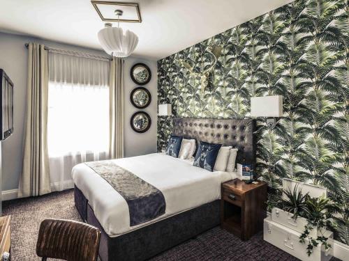 a bedroom with a large bed with a tropical wallpaper at Mercure Nottingham City Centre Hotel in Nottingham
