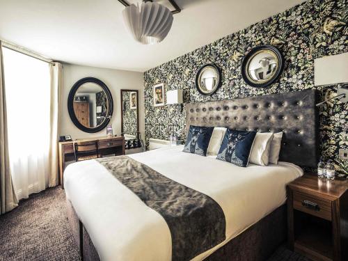 a bedroom with a large bed and a wall with wallpaper at Mercure Nottingham City Centre Hotel in Nottingham