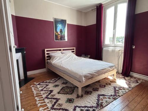 a bedroom with a bed and a purple wall at Maison chic et cosy in Roye