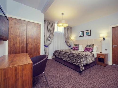 a hotel room with a bed and a desk at Mercure Nottingham City Centre Hotel in Nottingham