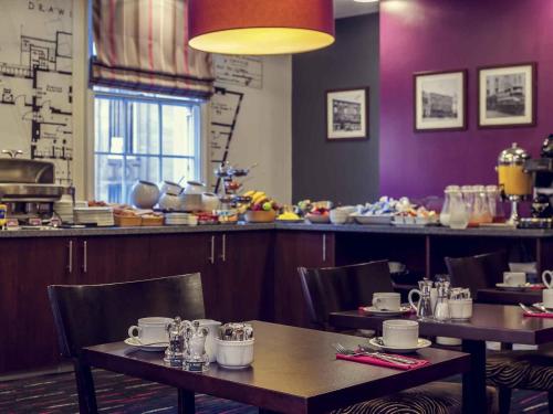a restaurant with tables and chairs and a counter at Mercure Nottingham City Centre Hotel in Nottingham