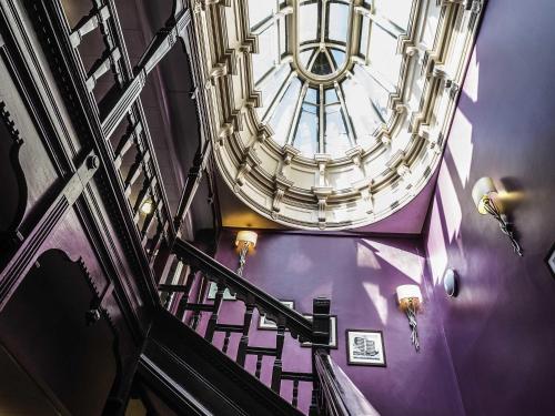 a spiral staircase with purple walls and a ceiling at Mercure Nottingham City Centre Hotel in Nottingham