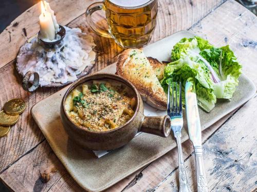 a table with a bowl of food and a plate of bread at Mercure Nottingham City Centre Hotel in Nottingham