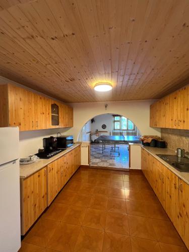 a large kitchen with wooden cabinets and a ceiling at Casa de Vacanta Cascada in Vidra
