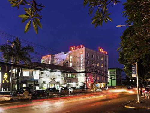 a city street at night with a building with neon signs at ibis Vientiane Nam Phu in Vientiane
