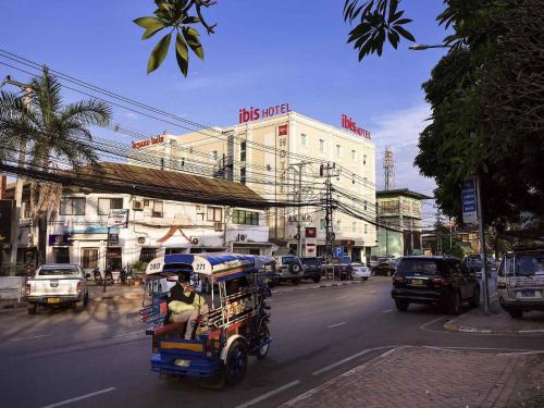 a man riding a rickshaw down a city street at ibis Vientiane Nam Phu in Vientiane