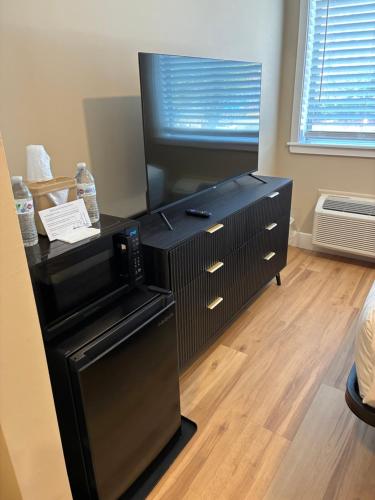 a black dresser with a tv on top of it at Mainstay Inn in Phoenixville