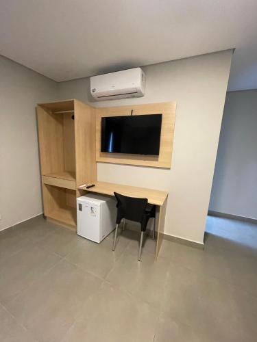 a room with a desk with a television and a chair at Hs Hotel Morumbi in Sao Paulo