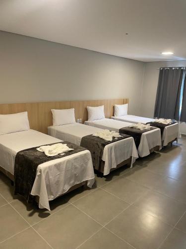 a group of three beds in a room at Hs Hotel Morumbi in Sao Paulo