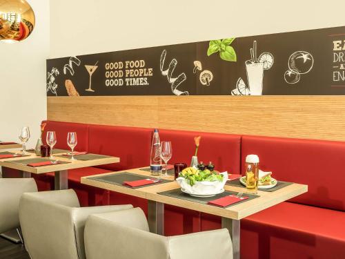 a restaurant with two tables and chairs with a bowl of food at ibis München City Süd in Munich