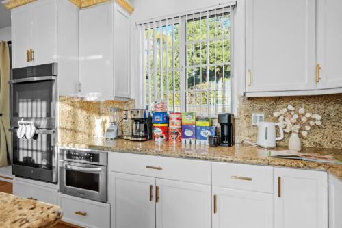 a kitchen counter with white cabinets and a window at Entire Private 4BR 2Bth, Pool, View, 4 Parking, King Bed, Big Yard in El Cajon