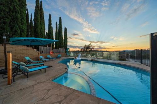 a large swimming pool with chairs and an umbrella at Entire Private 4BR 2Bth, Pool, View, 4 Parking, King Bed, Big Yard in El Cajon