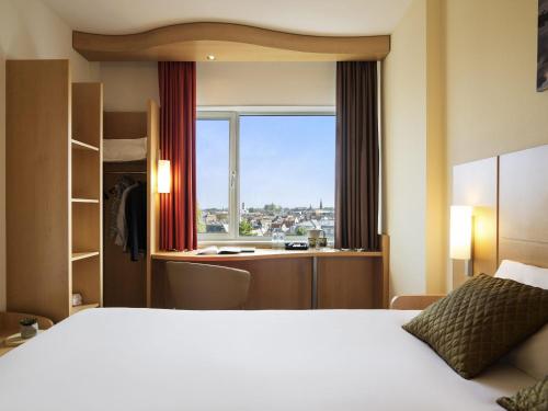 a hotel room with a bed and a window at ibis Leiden Centre in Leiden