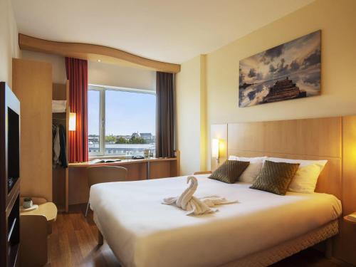 a hotel room with a bed with a towel on it at ibis Leiden Centre in Leiden