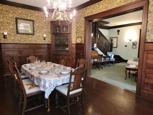 a dining room with a table and chairs and a chandelier at The Kings Throne Inn and Guest House in Toledo