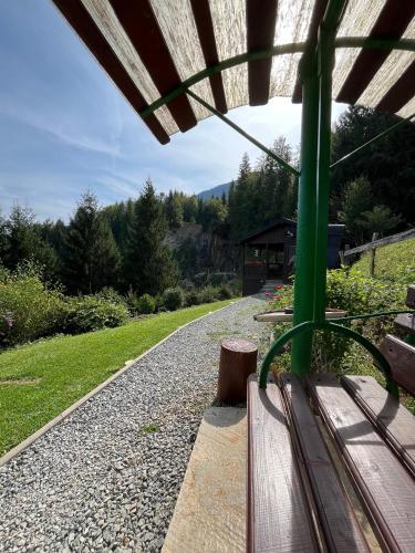 a wooden bench sitting next to a gravel road at Casa de Vacanta Cascada in Vidra