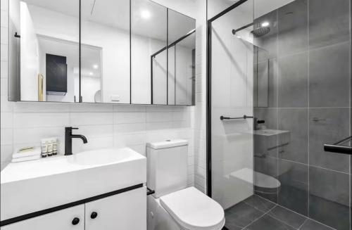 a bathroom with a toilet and a sink and a shower at Modern 1-Bedroom Apartment, Perfect City Getaway in Melbourne