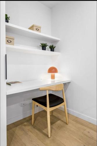 a desk with a chair and a lamp on it at Modern 1-Bedroom Apartment, Perfect City Getaway in Melbourne