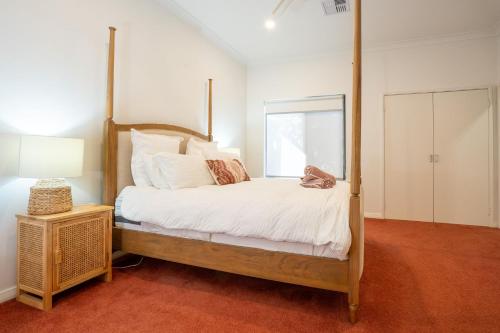 - une chambre avec un lit à baldaquin et un miroir dans l'établissement Valley View, à Dardanup
