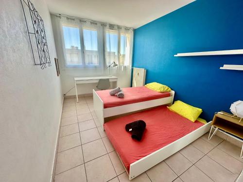 a small room with two beds and a bathroom at Grand et Bel appartement 6 personnes in Valence
