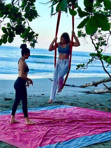 two women on the beach swinging on a blanket at La Posada del Mar in Dominical