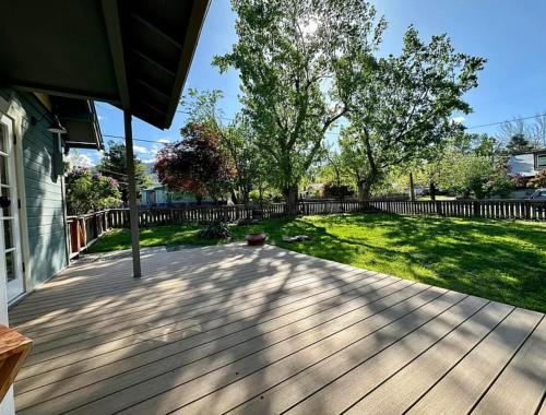 a wooden deck with a yard and a fence at Ashland Bungalow downtown in Ashland