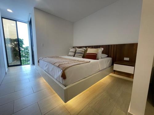 a bedroom with a bed and a large window at Amara 304- Amplio y comodo Apartamento en Laureles in Estación El Salto