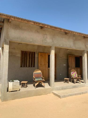 a porch of a house with chairs and tables at Diam Bougoum à MAR LODJ in Fimela