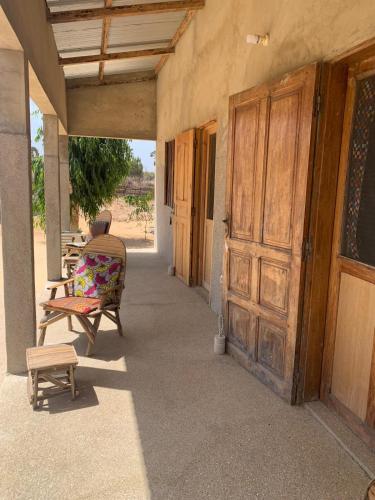 an empty porch with a large wooden door on a house at Diam Bougoum à MAR LODJ in Fimela