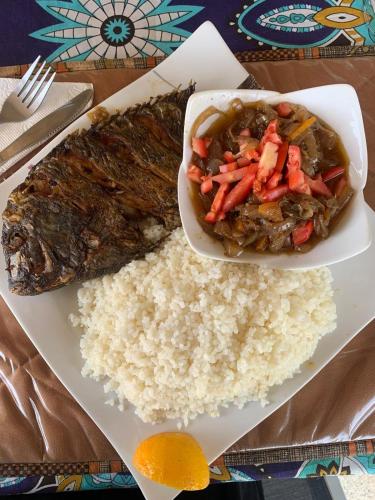 a plate of food with rice and a bowl of meat at Diam Bougoum à MAR LODJ in Fimela