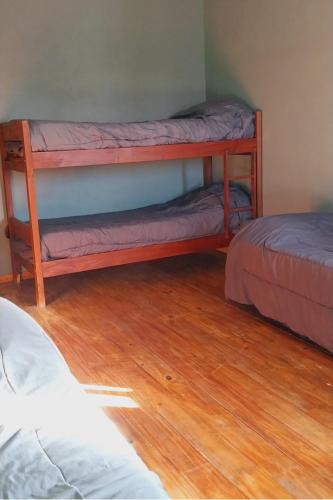 two bunk beds in a room with wooden floors at Duplex en Necochea in Necochea