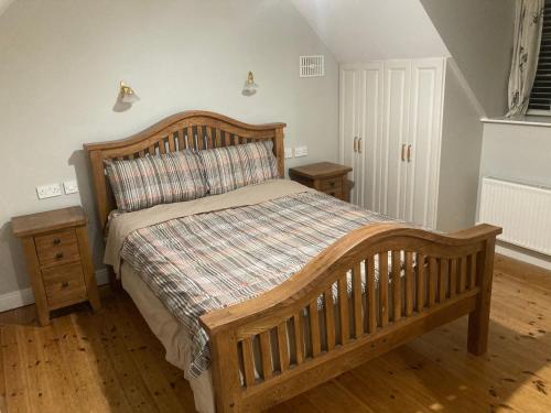 a bedroom with a wooden bed with a wooden headboard at Horse and Jockey Lodge in Tipperary