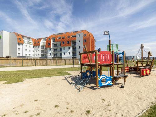 a playground in the sand in front of a building at ibis Styles Zeebrugge in Zeebrugge
