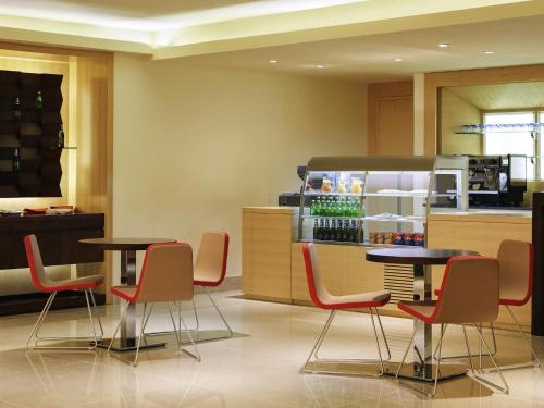 a restaurant with two tables and chairs and a refrigerator at Ibis Riyadh Olaya Street in Riyadh