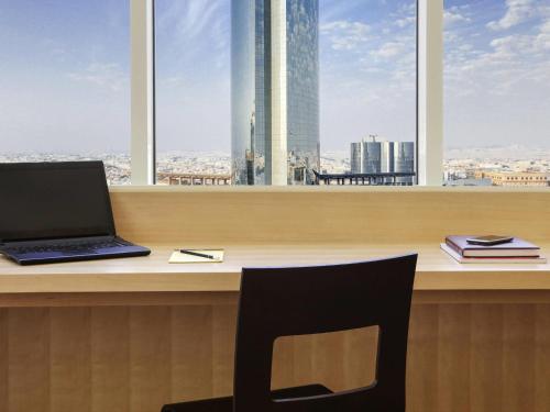 a laptop computer sitting on a desk in front of a window at Ibis Riyadh Olaya Street in Riyadh