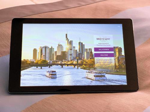 a tablet computer on a table with a view of a city at Mercure Hotel Kaiserhof City Center in Frankfurt/Main
