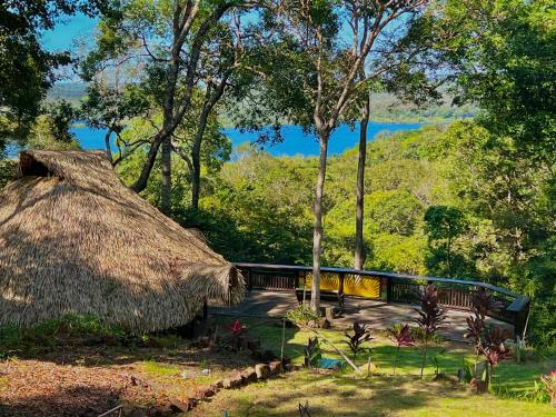 a hut with a thatch roof and a bench at CasAmor Hostel in Alter do Chao