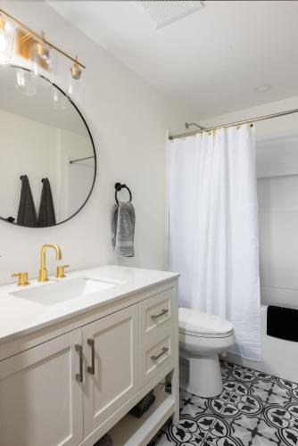 a bathroom with a sink and a toilet and a mirror at Ocean Vista In the Woods on Saltspring Island in Salt Spring Island