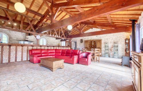 a living room with red couches and a wooden ceiling at Charmante Maison Avec Piscine in Saint-Pierre-dʼEyraud