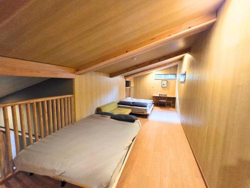a small room with a bed and a couch at Relaxing箱根彫刻の森ーサウナ付き一棟貸しの宿 in Hakone