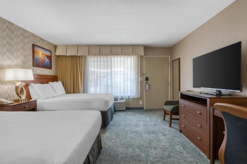 a hotel room with two beds and a flat screen tv at Best Western Seven Seas in San Diego