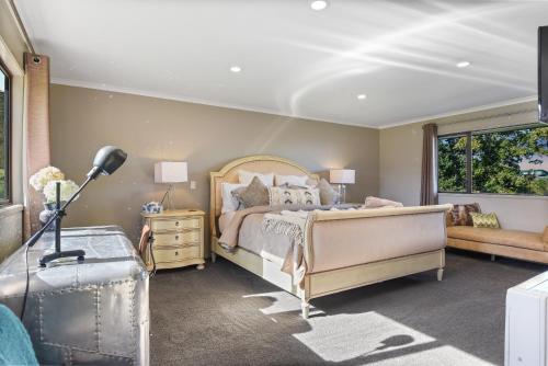 a bedroom with a bed and a window at Hamurana Lakeview Farmhouse Luxury Retreat in Hamurana