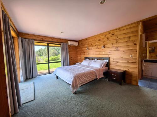 a bedroom with a bed and a large window at Beaver Farm House in Bombay