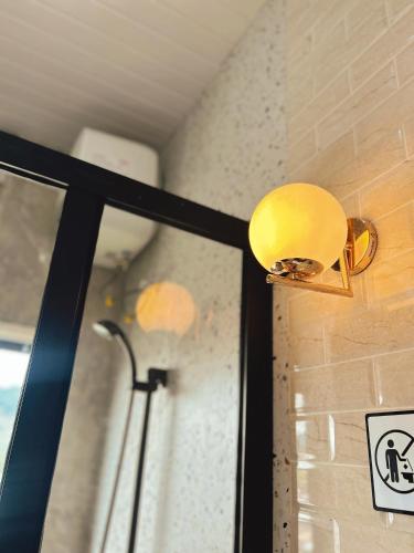 a yellow light on a wall next to a window at Sun Farm Dieng Villas in Dieng