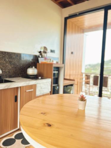 a kitchen with a wooden table with a potted plant on it at Sun Farm Dieng Villas in Dieng
