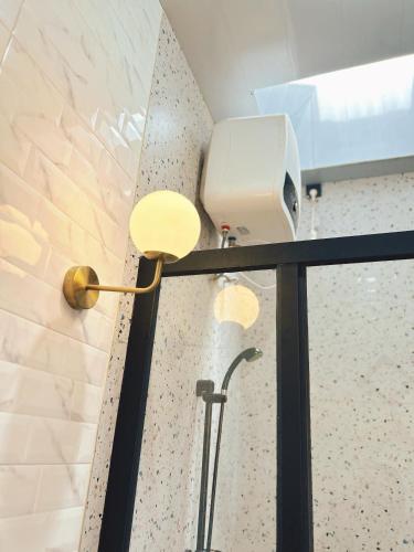 a lamp in a bathroom next to a wall at Sun Farm Dieng Villas in Dieng