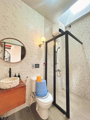 a bathroom with a toilet and a shower and a sink at Sun Farm Dieng Villas in Dieng
